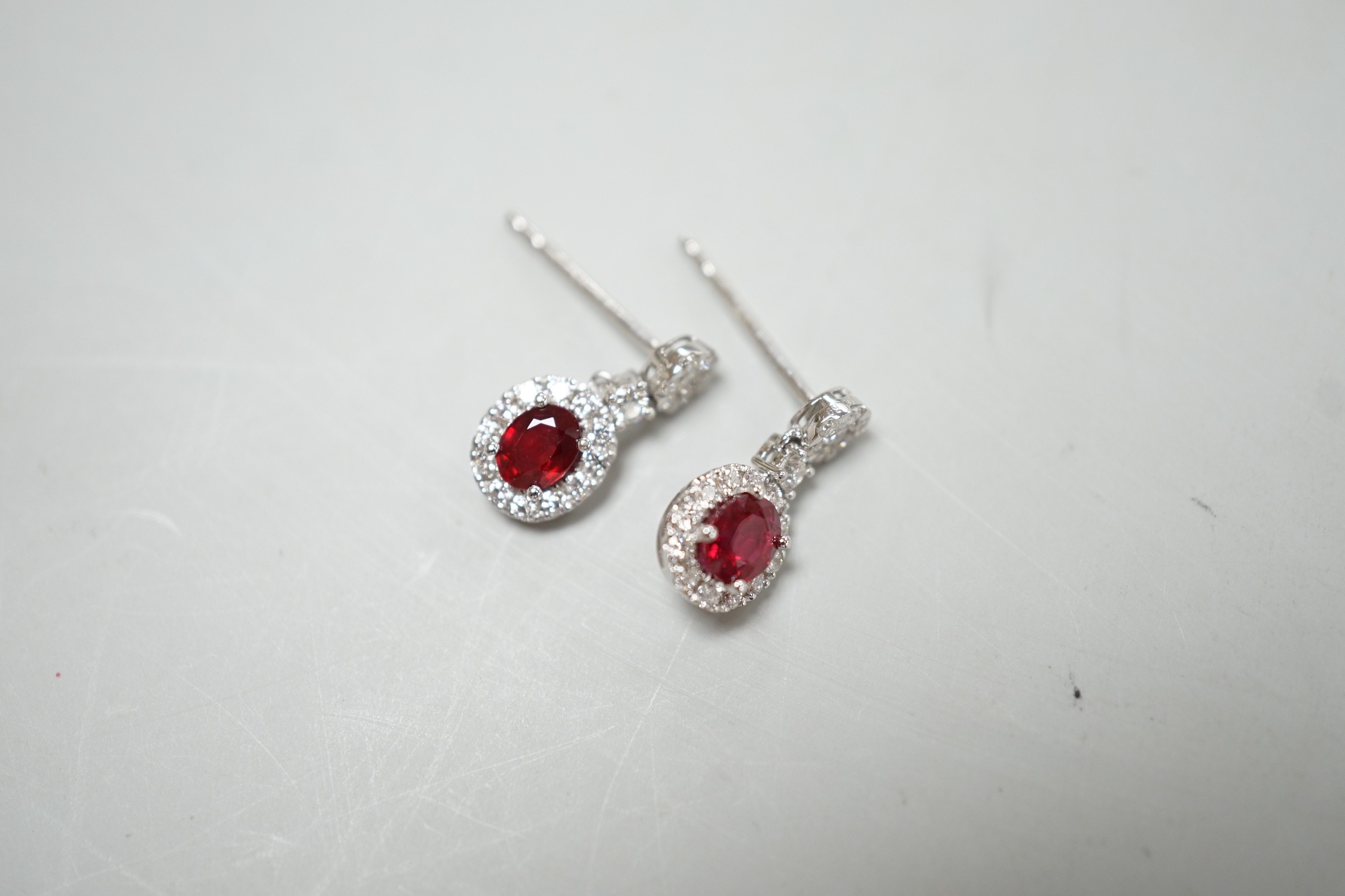 A modern pair of 750 white metal, ruby and diamond cluster set drop earrings, 13mm, gross weight 2.3 grams.